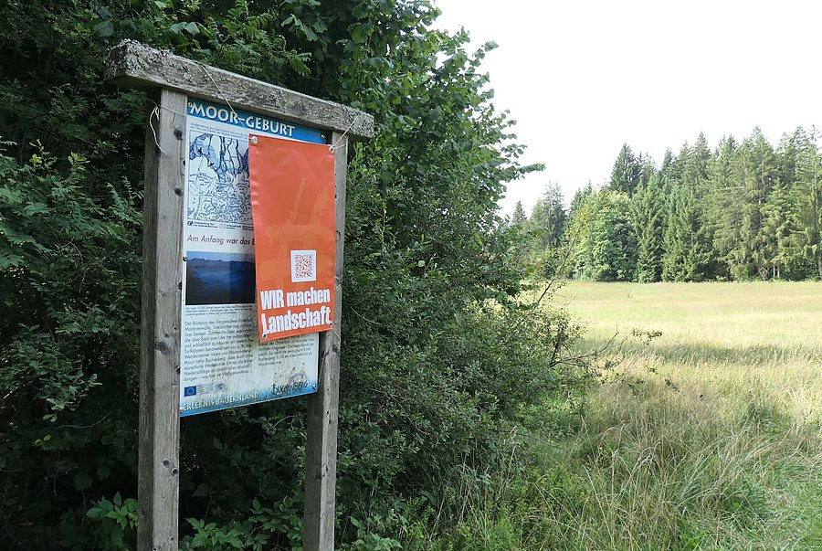 Roter Störbanner über Infoschild vor Pflegefläche