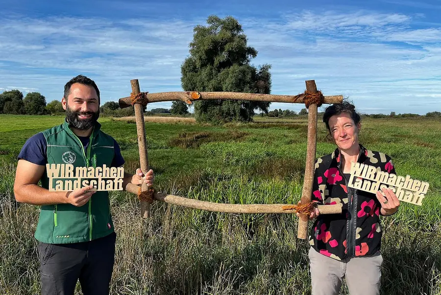 Personen mit Schriftzug vor Landschaft
