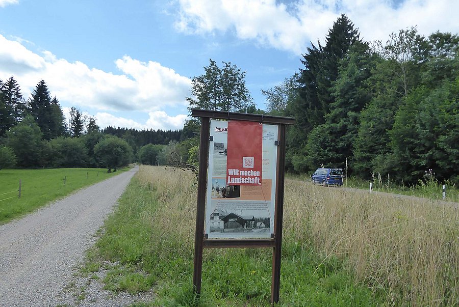 Rotes Störbanner über Infoschild an Radweg