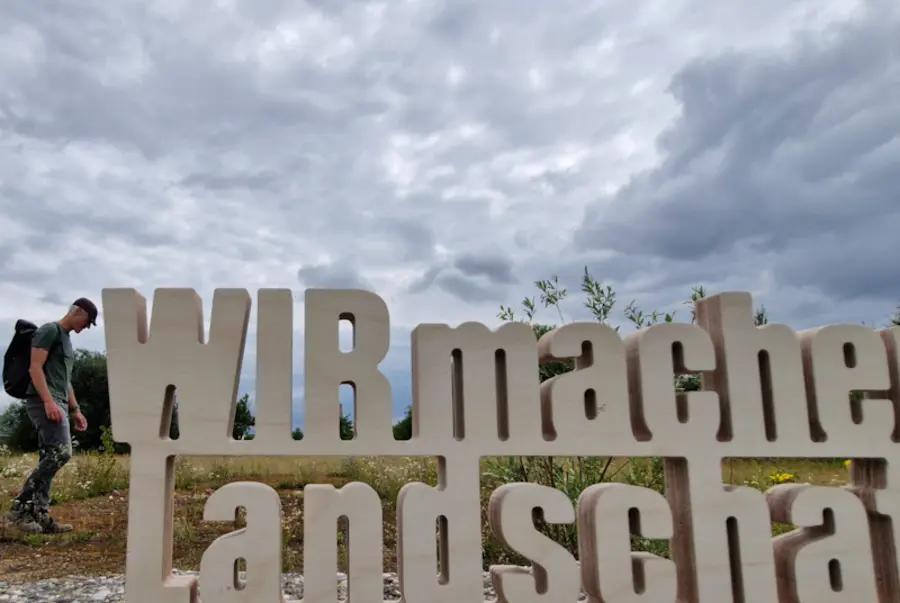 Schriftzug neben Spaziergänger