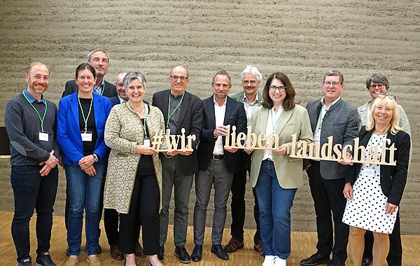 Bayerischer Landschaftspflegetag 2024 ©DVL Teilnehmede des Bayerischen Landschaftspflegetags halten den Schriftzug #wirliebenlandschaft hoch.